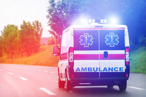 Ambulance flashing lights on suburban road