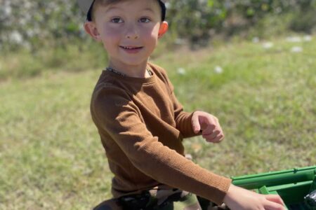 boy playing with tractor outside