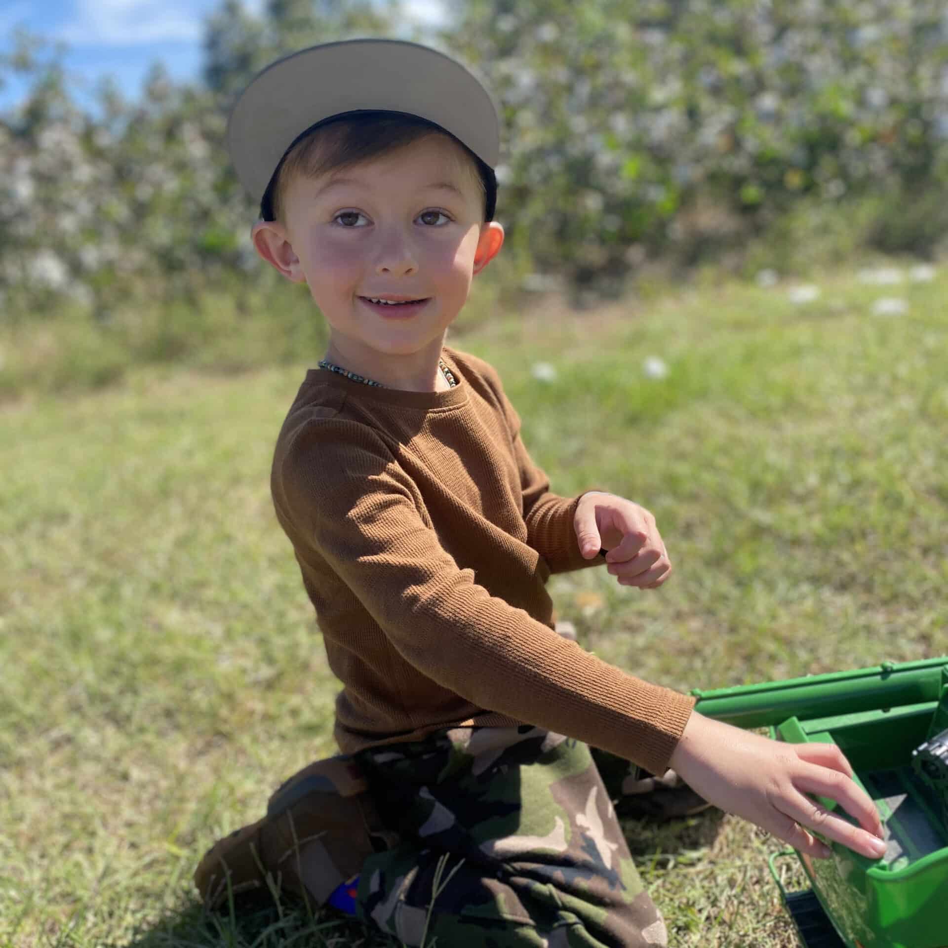 boy playing with tractor outside